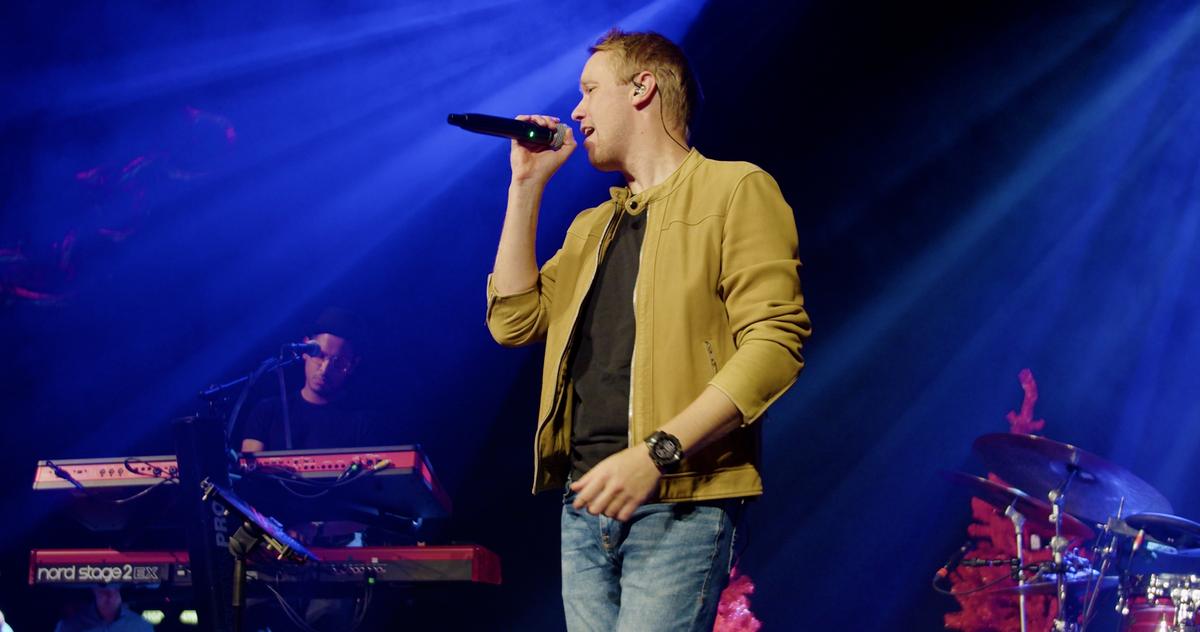 Forsanger med mikrofon i blåt lys